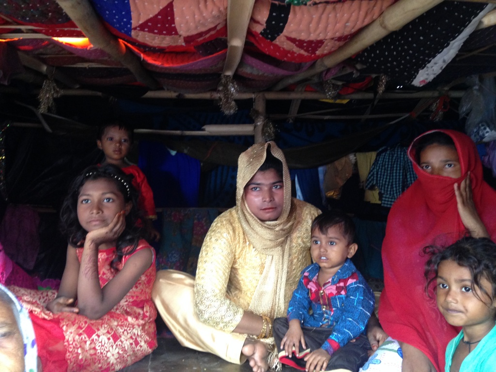 A group of Rohingya refugees wait out the rain before a trip to the nearest market, Nangli Camp 3, Mewat Haryana, India (2)